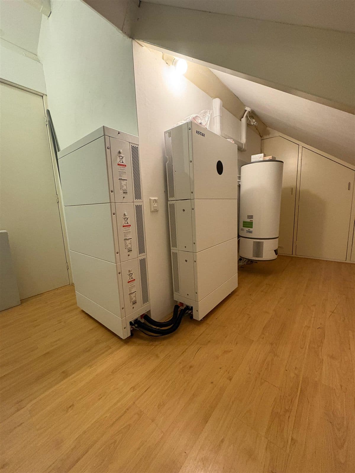 Thuisbatterij en omvormer binnen op zolder geplaatst, met kort en netjes weggewerkte kabels